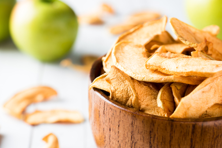 Dried apples in a wooden bowl Ripe green apples on the table.の写真素材