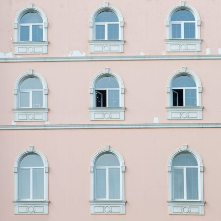 Exterior of the house with pink walls and arched Windows.