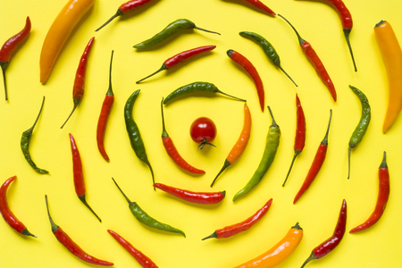 Assorted chili pepper tomato cherry On yellow bright background.の写真素材