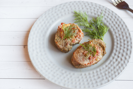 Delicious pieces of baked meat with fresh vegetables on the table.の写真素材