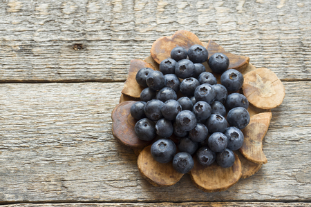 Blueberries on old wooden dishes, space for text.の写真素材