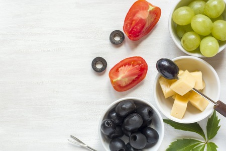 Ingredients for snacks, cheese with olives on a white table with copy spaceの写真素材