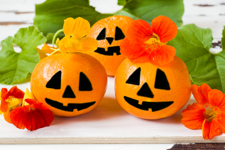 Drawn funny faces on Mandarin oranges for Halloween.の写真素材
