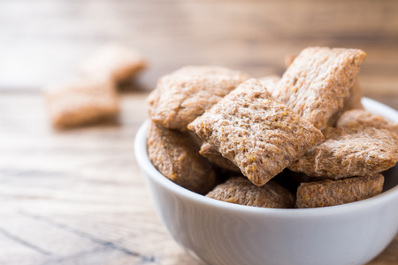 Cookies crackers square shape in a plate on a wooden tableの写真素材
