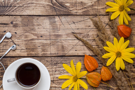 Autumn flowers and a Cup of coffee on a wooden background with a copy of the space