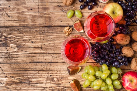 Cheese, wine, baguette grapes figs honey and snacks on the rustic wooden tableの写真素材