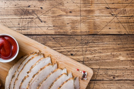 Pieces of smoked boiled pork on a wooden rustic Board with bread, sauces and spices on a wooden table. Copy space.の写真素材