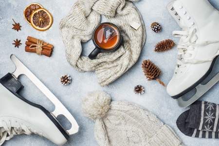 Winter vacation concept. Skates warm clothes, Cup of hot tea with fragrant spicesの写真素材