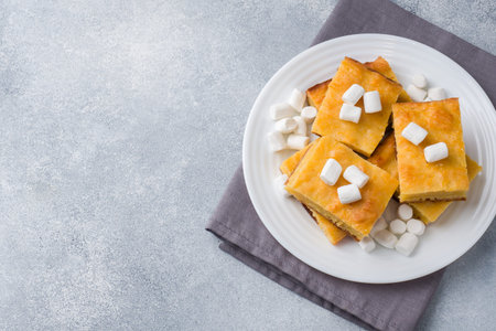 Pieces of delicious pumpkin pie with marshmallow and nuts on a plate copy space