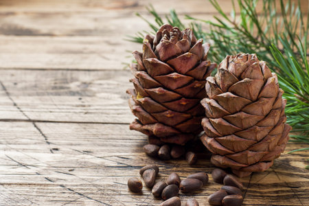 Cedar cones and nuts on wooden background. Selective focus.Copy space.
