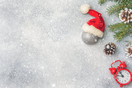 Christmas scenery, toys and branches fir on grey background. New Year concept Copy space.