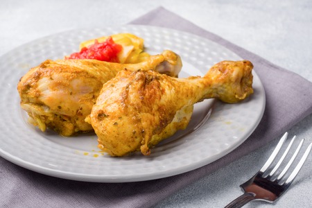 Baked chicken leg Shin with vegetables tomato zucchini on a plateの写真素材