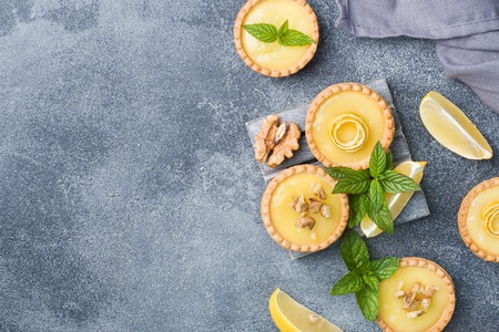 Homemade lemon curd in tartlets with fresh lemon and mint leaves Copy spaceの写真素材