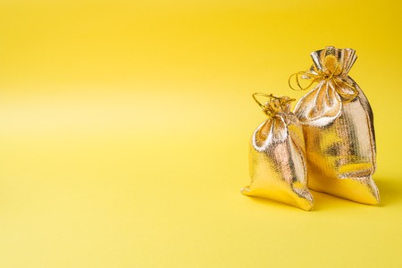 Christmas new year concept. Golden gift bag on a yellowの写真素材