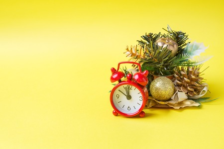 Christmas new year concept. Santa hat Christmas Tree cones gifts clock on yellowの写真素材