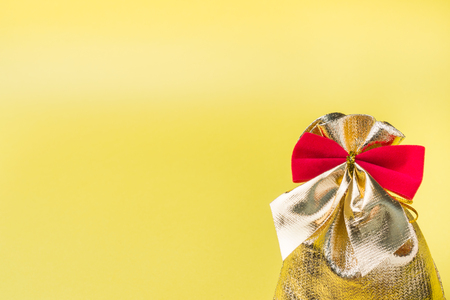 Christmas new year concept. Golden gift bag on a yellowの写真素材