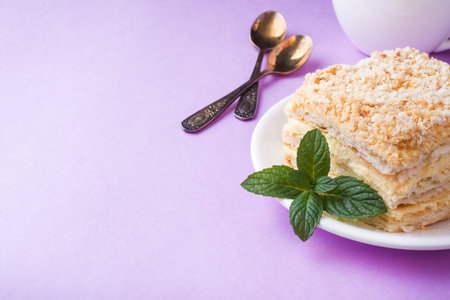 Puff cake with cream Napoleon Millefeuille vanilla slice with mint color on purple background