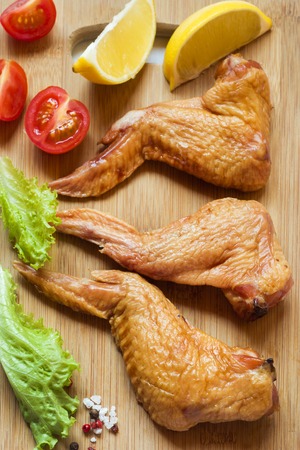 Smoked chicken wings with fresh lettuce tomato and lemon.の写真素材