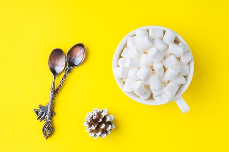 Marshmallow in a mug on a yellow background. The concept of Christmas and New Yearの写真素材