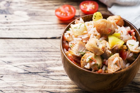 Stewed rice with chicken and vegetables in a wooden bowlの写真素材