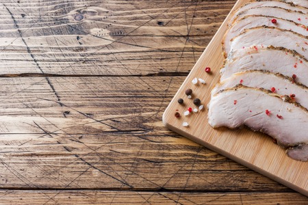 Pieces of smoked boiled pork on a wooden rustic Board with bread, sauces and spices on a wooden table. Copy space.の写真素材