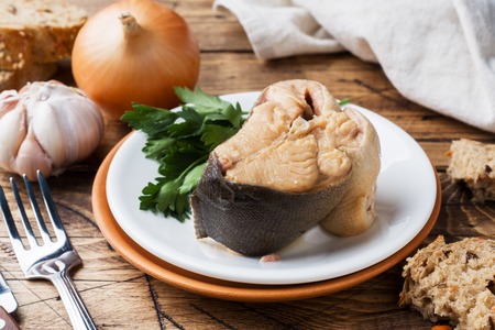 Ingredients for salmon fish soup, pieces of bread, onion and garlic with greens on wooden backgroundの写真素材