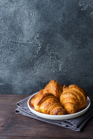 Freshly baked croissants on a plate, dark background, copy spaceの写真素材