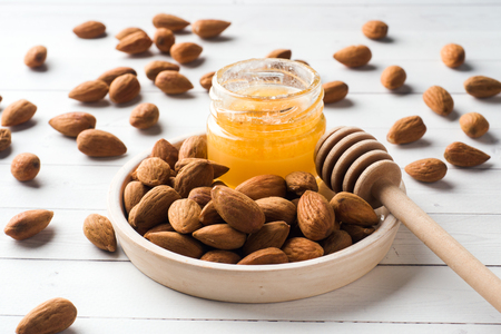 Almonds and a can of honey on the table. Selective focusの写真素材