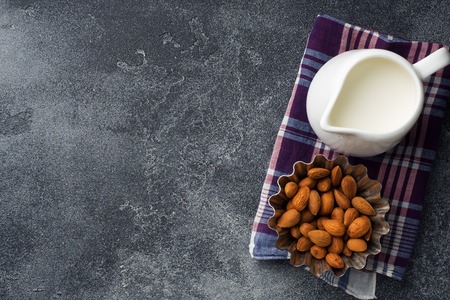 Almonds in a bowl and milk on the table. Selective focus. Copy spaceの写真素材