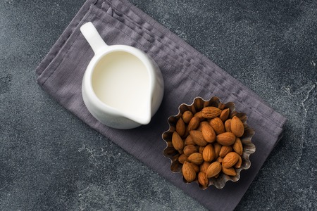 Almonds in a bowl and milk on the table. Selective focus. Copy spaceの写真素材