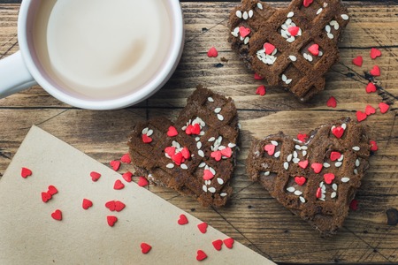 Concept Valentine's Day. Cup of coffee and cookies on a wooden table. Greeting cardの写真素材