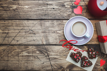 Concept Valentine's Day. Cup of coffee and cookies on a wooden table. Greeting card Copy space
