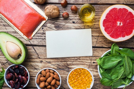 Concept Healthy food antioxidant products: fish and avocado, nuts and fish oil, grapefruit on wooden background Copy spaceの写真素材