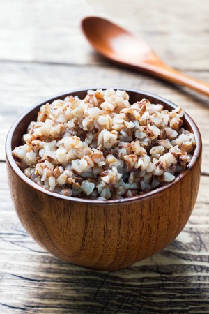 Boiled buckwheat in a wooden bowl on the village tableの写真素材