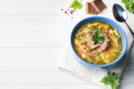 Russian traditional cabbage soup with meat and fresh herbs on a light table Copy spaceの写真素材