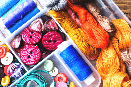 Sewing tool for needlework. colored threads, centimeter and buttons with a pair of scissors on the table. close-upの写真素材