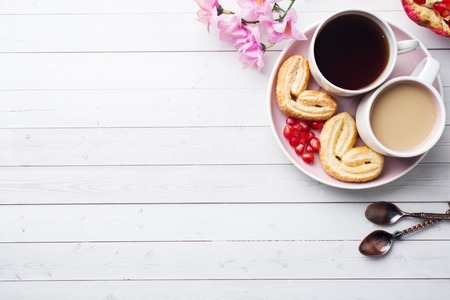 Valentine's day Breakfast concept. Cup of coffee and a cookies hearts on a white table two persons. copy space, flat layの写真素材
