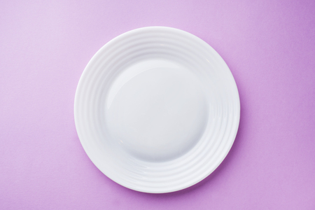 Empty white plate on pink background close upの写真素材