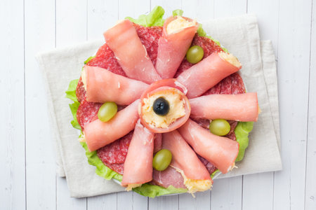 ham rolls with cheese and sausage on a plate.
