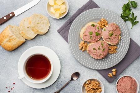 Breakfast on the table. Chicken pate and butter sandwiches. Cup of tea.の写真素材