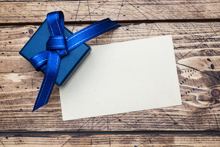 Blue gift box with ribbons and space for text on wooden tableの写真素材