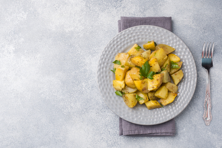 Baked potatoes with spices and herbs on a plate. Copy spaceの写真素材