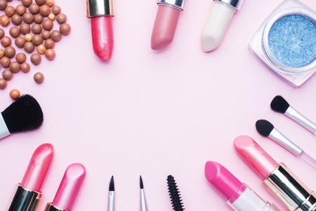 Professional makeup tools. Brushes lipstick blush eye shadow on a pink pastel  with copy space. Flat lay.の写真素材