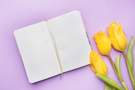 Overhead view of a bouquet of tulips and notebook. copy space. Flat lay, top viewの写真素材