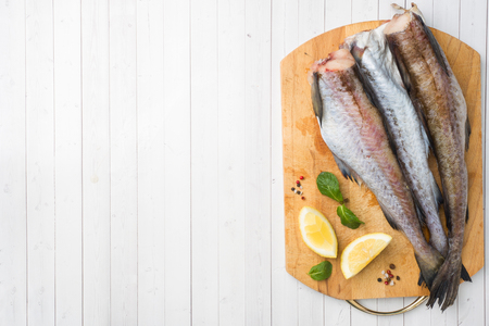 Raw fresh Pollock fish on a wooden Board with lemon. Copy spaceの写真素材