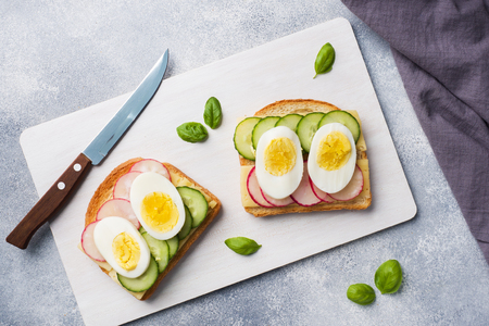 Sandwiches with egg cheese, fresh cucumber and radish. concept healthy Breakfastの写真素材
