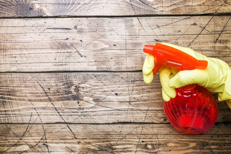 Bottles with detergents and cleaning products on wooden background. Home cleaning concept. Top view, copy spaceの写真素材
