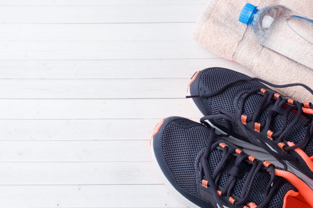 Healthy lifestyle, food and water, athlete's equipment on grey background. Flat lay. Top view with...