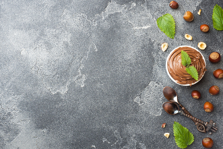 Nougat nut chocolate in a plate on a dark concrete background with hazelnut nuts. Concept of Breakfast Copy space.の写真素材