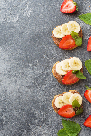 Delicious sandwiches with chocolate nougat, strawberry and banana. Concept of Breakfast. Dark concrete background Copy space.の写真素材